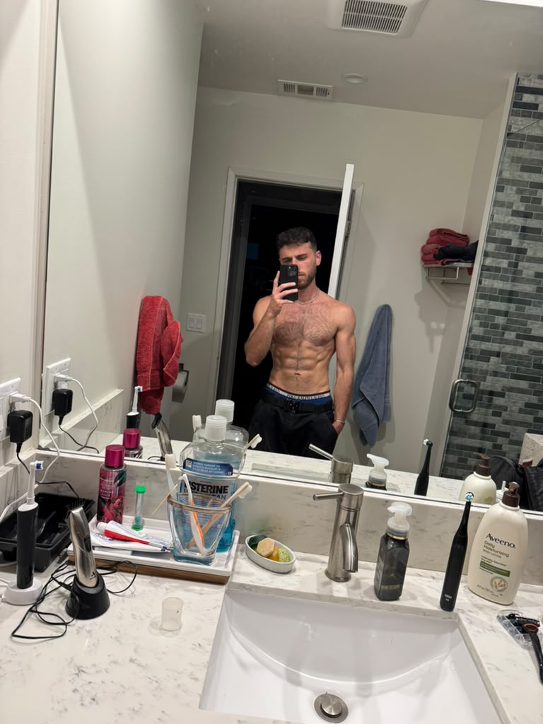 Leead photographed in a bathroom mirror in July 2026, after a year of daily hanging and progression work.